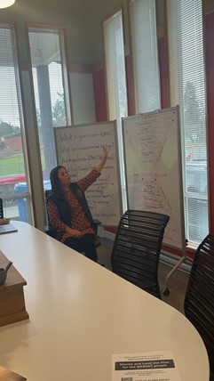 W̱SÁNEĆ Leadership Council Policy and Negations Manager Joni Olsen points to a whiteboard.